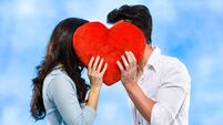 Couple kissing behind the red heart