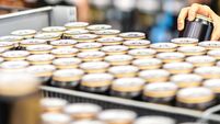 Retail worker filling shelf with drinks in grocery store or customer taking can of beer or soda. Staff at supermarket stocking s
